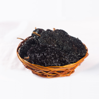 Close-up frontal shot of ancho chili in a wooden basket.